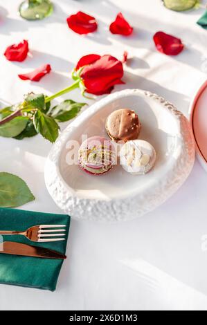 Una pila di macaron. Composizione primaverile di macaron con fiori. Foto Stock