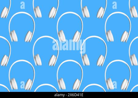 Moderno motivo di cuffie wireless bianche su sfondo blu. Foto Stock