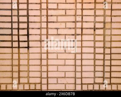 Primo piano della parete in mattoni beige testurizzati, prospettiva a livello degli occhi Foto Stock