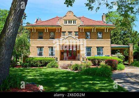 Elegante casa in mattoni dell'inizio del XX secolo con vegetazione lussureggiante, Sunny Day Foto Stock