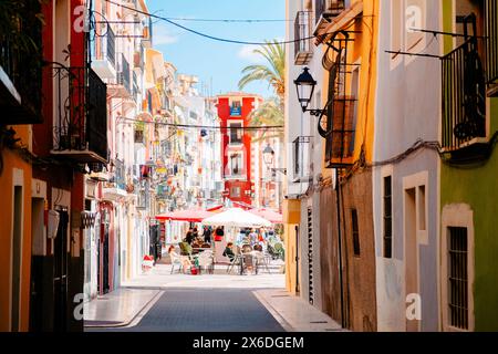 La Vila Joiosa, Spagna - 24 aprile 2024: Vista sulla splendida via Villajoyosa con case multicolore. Villajoyosa - città costiera nella provincia di Alicante Foto Stock