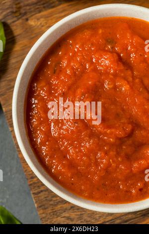 Salsa di pomodoro biologico crudo rosso per pizza in ciotola con basilico Foto Stock