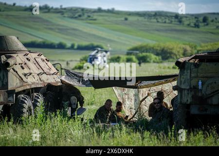 Campia Turzii, Romania. 14 maggio 2024. I paracadutisti della Bundeswehr riposano tra i vecchi carri armati durante l'esercitazione aerea Swift Response. La NATO descrive l'esercitazione come la più grande operazione aviotrasportata dalla seconda guerra mondiale. Lo scenario dell'esercitazione è la liberazione di un campo d'aviazione contro le forze nemiche. Crediti: Kay Nietfeld/dpa/Alamy Live News Foto Stock