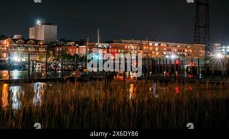 NORWALK, Connecticut, USA- 13 MAGGIO 2024: La scena notturna di Norwalk cattura l'essenza di un fiume Norwalk di notte, con edifici luminosi che costeggiano il lungomare Foto Stock