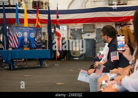 7 maggio 2024 - Miami, Florida, Stati Uniti - gli ospiti che partecipano a una cerimonia di naturalizzazione a bordo della nave d'assalto anfibia USS Bataan (LHD 5) guardano un messaggio trasmesso in televisione dal presidente Joe Biden durante la Fleet Week di Miami, 7 maggio 2024. Le Fleet Weeks sono una tradizione della Marina degli Stati Uniti, del corpo dei Marines e della Guardia Costiera, dove le principali città degli Stati Uniti ospitano Marines, marinai e guardie costiere per una settimana di eventi a livello comunitario. Fleet Week Miami, nel suo primo anno, è un'opportunità per residenti e visitatori di incontrare i membri del servizio, promuovere le relazioni con la comunità e visualizzare le ultime funzionalità dell'odierno maritim Foto Stock