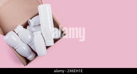 Flaconi in plastica bianca confezionati ordinatamente in una scatola di cartone Foto Stock