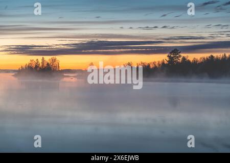 Il sole sorge nel Minnesota settentrionale, vicino a Duluth, su una splendida scena di laghi, mentre il vapore sale dalle acque calme Foto Stock