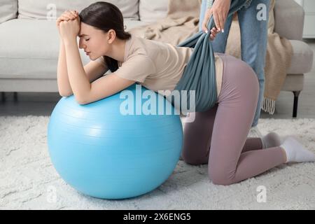 Doula lavora con una donna incinta a casa. Preparazione alla nascita del bambino Foto Stock