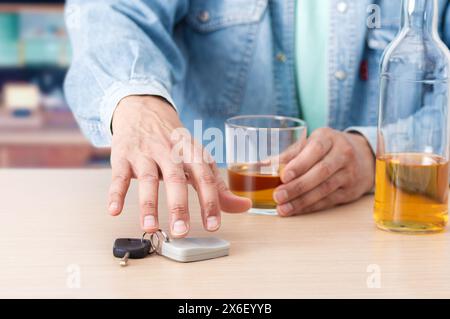 Uomo bere birra a mano e tenere le chiavi dell'auto Foto Stock