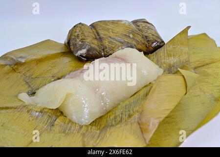 Il Khao Tom Mat o dessert di riso appiccicoso alla banana tailandese al vapore è visto come un simbolo per le coppie, in quanto tipicamente viene impacchettato e venduto in coppia Foto Stock