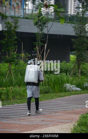 Un uomo porta con sé uno zaino elettronico pesante Apple Maps montato su quattro fotocamere per scattare foto mentre cammina lungo un percorso designato. Singapore. Foto Stock