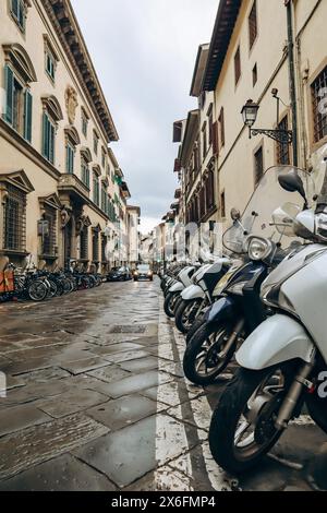 Firenze, Italia - 29 dicembre 2023: Veduta di una stradina nel centro di Firenze e degli scooter parcheggiati su di essa Foto Stock