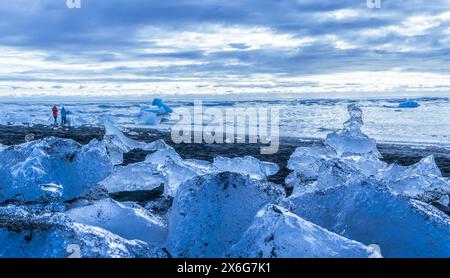 Un grande specchio d'acqua con molto ghiaccio sulla riva. Il cielo è nuvoloso e l'acqua è blu Foto Stock