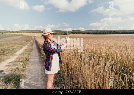 Donna campo di grano. Agronomo, agricoltore donna che controlla i picchi d'orzo maturo dorato nel campo coltivato. Primo piano della mano femminile sulla piantagione in agricoltura Foto Stock