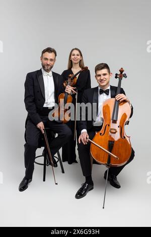 Musicisti eleganti con contrabbasso e violini Foto Stock