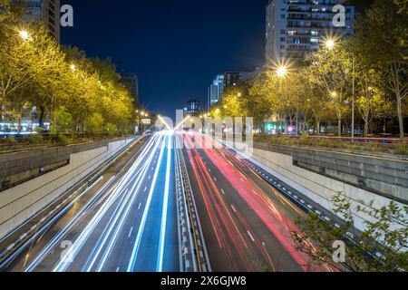 Vista notturna panoramica del Paseo de la Castellana avenue nella città di Madrid, Spagna, Europa. Si possono vedere le strisce di luce delle auto che passano Foto Stock