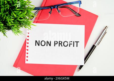 Testo senza scopo di lucro scritto su un pezzo di carta strappato appoggiato su un taccuino Foto Stock