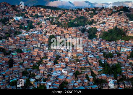 Vista aerea di Caracas al tramonto con il quartiere di Petare, il più grande baraccopoli del Venezuela e dell'america latina, con la montagna di Avila nel backgro Foto Stock