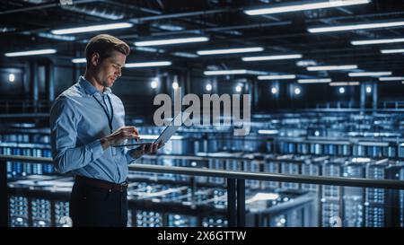 Ritratto di Specialisti IT utilizza notebook nei data center. Struttura di cloud computing Server Farm con amministratore di manutenzione maschile in funzione. Sicurezza informatica e protezione della rete. Foto Stock