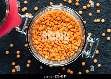 vista dall'alto, primo piano del vaso di vetro con lenticchie rosse asciutte. Foto Stock