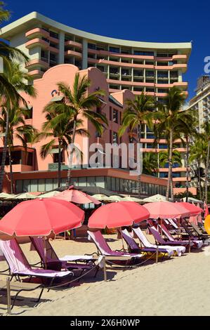 Gli ombrelloni Pink Beach sono allineati nel carattere dello storico Royal Hawaiian Hotel, conosciuto anche come il Pink Palace, sulle sabbie di Waikiki Beach, Hawaii Foto Stock