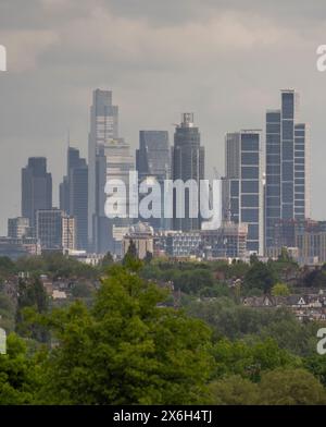 Wimbledon Londra, Regno Unito. 15 maggio 2024. Viste lontane dei grattacieli del centro di Londra scintillanti in una foschia di calore mentre il tempo si riscalda di nuovo con i sobborghi verdi in primo piano. Crediti: Malcolm Park/Alamy Foto Stock
