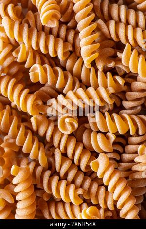 sfondo con pasta integrale italiana. fusilli Foto Stock