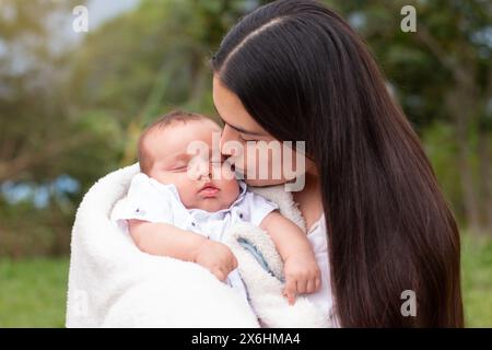 stile di vita: la madre bacia il viso del suo bambino addormentato Foto Stock