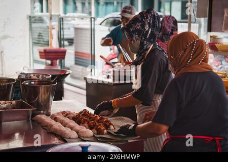 Penang, Malesia - 1 novembre 2022: Donne malesi hijab preparano cibo al famoso Ali Nasi Lemak Daun Pisang a Sri Weld Food Court, Beach Street. Foto Stock