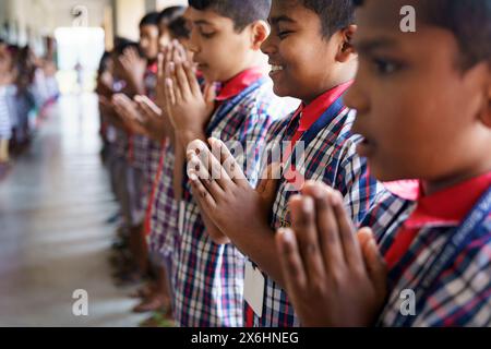 Kolkata, India - 20 ottobre 2024: Bambini in uniforme che sorridono e cantano l'inno nazionale per la routine mattutina della scuola indiana. Concetto di crescita, ed Foto Stock