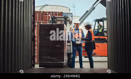 Carrello elevatore a forche caricamento container carico di spedizione con pallet completo con scatole nel terminal porto logistico. Supervisore industriale e ispettore di sicurezza femminile latina con discussione sui tablet, processo di gestione. Foto Stock