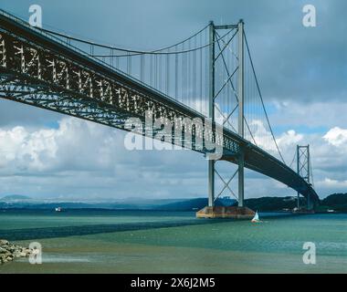 Il vecchio Forth Road Bridge, in Scozia, fu aperto nel 1964, collegando Edimburgo a Fife. Trasporta la A9000 sul Firth of Forth tra South Queensferry e North Queensferry. Non è più possibile guidare sopra di essa, anche se rimane aperto a autobus, taxi e camminatori. Il traffico generale ora utilizza l'autostrada M90 che attraversa il vicino Queensferry Crossing, aperto nel 2017. Questa fotografia è stata fatta nel 1990, molto prima che il Queensferry Crossing fosse costruito (ora sarebbe visibile sullo sfondo di questa vista). Foto Stock