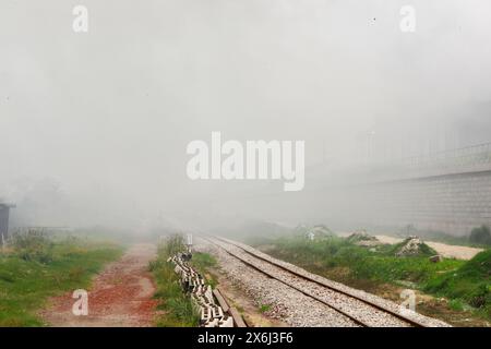 Dacca, Bangladesh. 15 maggio 2024. La gente passa un'area industriale mentre il fumo sale dai mulini rilaminati a Shyampur, a Dacca, Bangladesh, 15 maggio 2024. Secondo uno studio della Banca mondiale, il Bangladesh deve affrontare un elevato livello di inquinamento atmosferico, che costa circa il 9% del PIL all'anno. La maggior parte dei laminatoi in acciaio all'interno e intorno alla capitale sono stati eseguiti senza il necessario sistema di controllo dell'inquinamento atmosferico che poneva un rischio di inquinamento atmosferico e di pericolo per la salute. (Credit Image: © Suvra Kanti Das/ZUMA Press Wire) SOLO PER USO EDITORIALE! Non per USO commerciale! Foto Stock