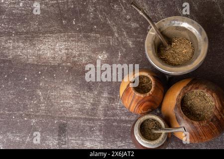 Sana bevanda infusi, classico tè Yerba Mate in una buca con bombilla e erba su sfondo grigio chiaro. Foto Stock