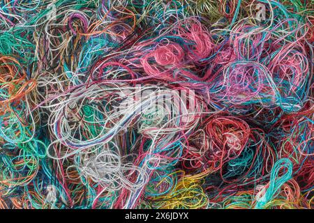 trama di fondo con fili da cucito colorati aggrovigliati, astratta presa dall'alto in full frame Foto Stock