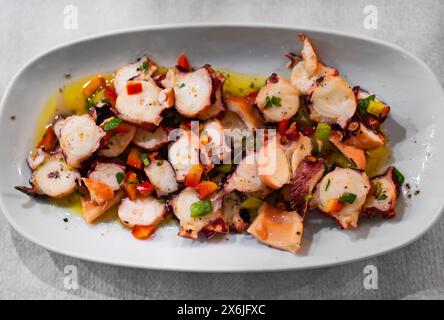 Insalata di polpo condita con olio d'oliva e verdure. Foto Stock