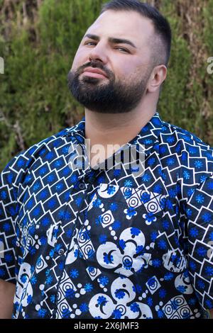 Questo straordinario ritratto raffigura un uomo di 30 anni vestito da un'elegante camicia blu decorata da intricati motivi bianchi. Foto Stock