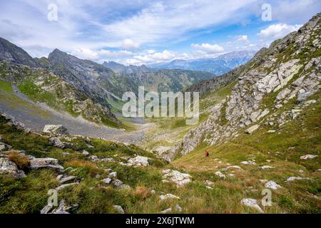 Alpinista su un sentiero escursionistico in sella, vista sulla valle Obergailtal presso Obergailtaler Joch, Carnic Main Ridge, Carnic Alps, Carinthia Foto Stock