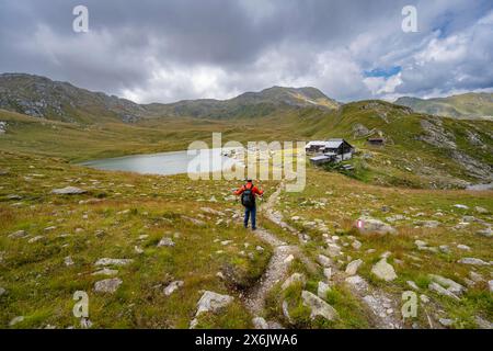 Alpinista su un sentiero escursionistico fino al rifugio Obstanserseehuette presso il lago di montagna Obstansersee, Carnic Main Ridge, Carnic High Trail, Carnic Foto Stock