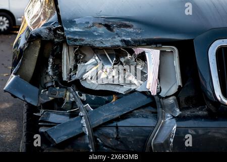 Dettaglio di un faro rotto su un'auto blu scuro dopo un incidente stradale Foto Stock