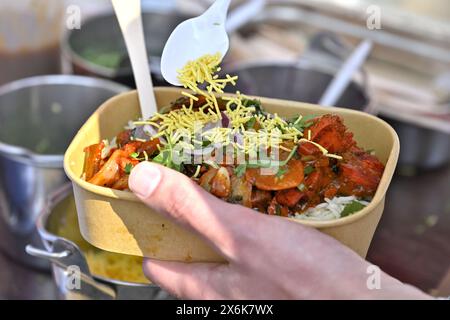 Primo piano del cibo da asporto indiano, curry con riso, in una ciotola di cartone conforme alle moderne direttive sui rifiuti del Regno Unito, dallo stallo del mercato Foto Stock
