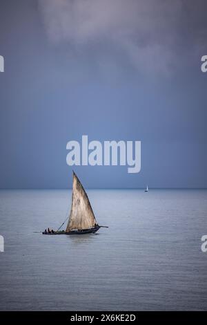 Barca a vela tradizionale in sambuco con nuvole di tempesta sullo sfondo, Stonetown, Zanzibar City, Zanzibar, Tanzania, Africa Foto Stock