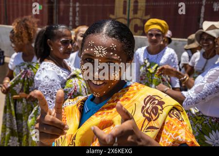 Felice donna locale con il dipinto di faccia decorativo Masonjoany durante uno spettacolo di danza tradizionale, Mahajanga, Boeny, Madagascar, Oceano Indiano Foto Stock