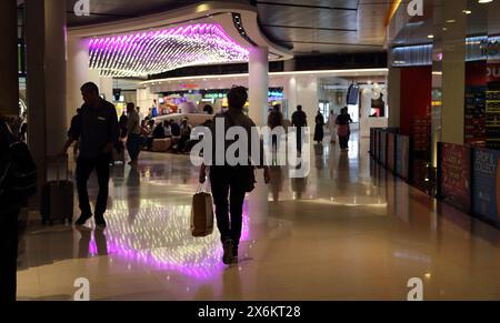 Turisti e gente del posto con i bagagli all'Aeroporto Internazionale di Muscat Oman Foto Stock