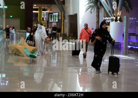 Turisti e gente del posto con i bagagli all'Aeroporto Internazionale di Muscat Oman Foto Stock