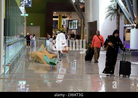 Turisti e gente del posto con i bagagli all'Aeroporto Internazionale di Muscat Oman Foto Stock