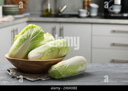 Cavoli cinesi freschi su tavolo di legno grigio, spazio per il testo Foto Stock