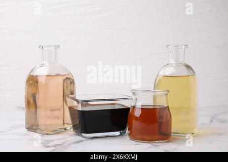 Diversi tipi di aceto su tavolo in marmo chiaro, primo piano Foto Stock
