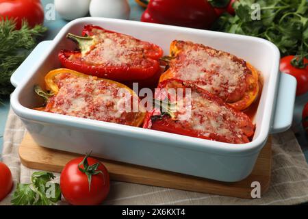 Gustosi peperoni ripieni in piatto e ingredienti in tavola Foto Stock