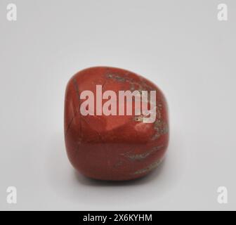 Primo piano di una pietra rossa lucida Jasper su sfondo bianco Foto Stock